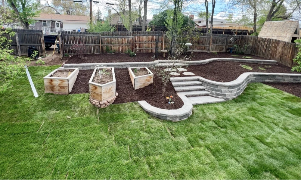 Retaining wall with steps surrounding raised garden beds.